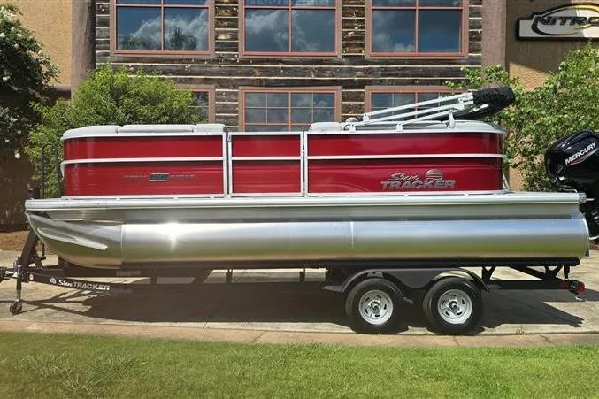 The Image of 2026 Sun Tracker Party Barge 20 DLX pontoon boat on trailer, parked outdoors. - 0