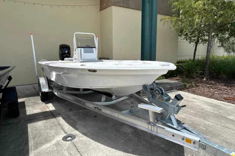 Slide: The Image of 2026 Mako 18 Pro Skiff on trailer, parked outdoors near greenery. - 3