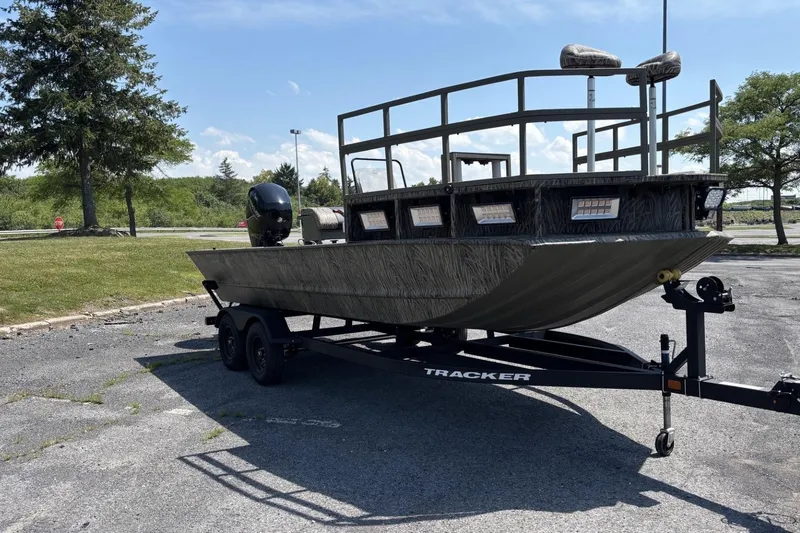 The Image of 2026 Tracker Grizzly 2072 CC Sportsman Kicker boat on trailer in parking lot. - 0