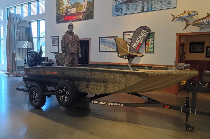 The Image of 2026 Tracker Grizzly 1756 T Marsh boat displayed indoors with camouflage design. - 0