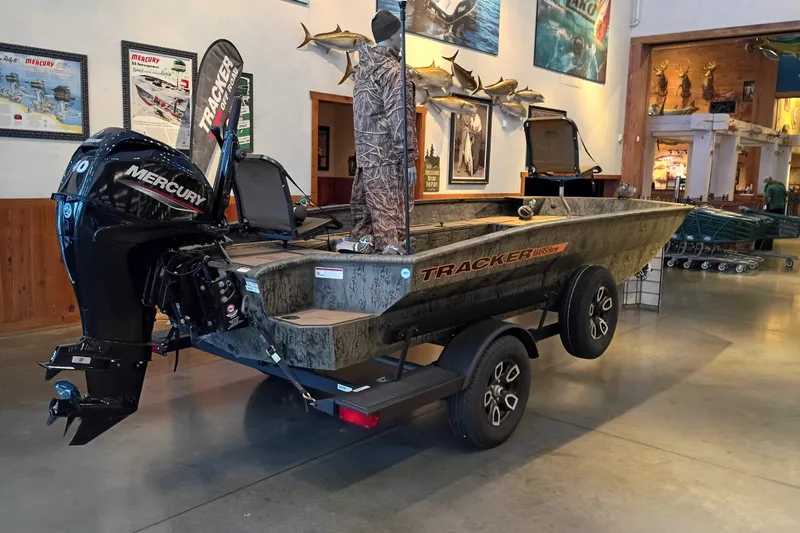 Slide: The Image of 2026 Tracker Grizzly 1756 T Marsh boat displayed indoors with Mercury engine. - 2