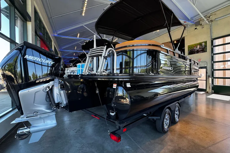 Slide: The Image of 2026 Regency 230 DL pontoon boat with Mercury engine in showroom setting. - 1