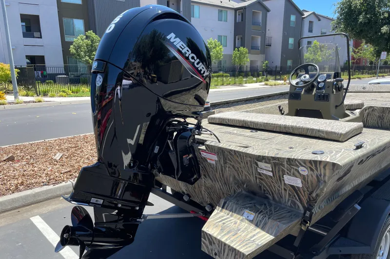 Slide: The Image of 2026 Tracker Grizzly 2072 CC boat with Mercury outboard motor in a parking lot. - 3