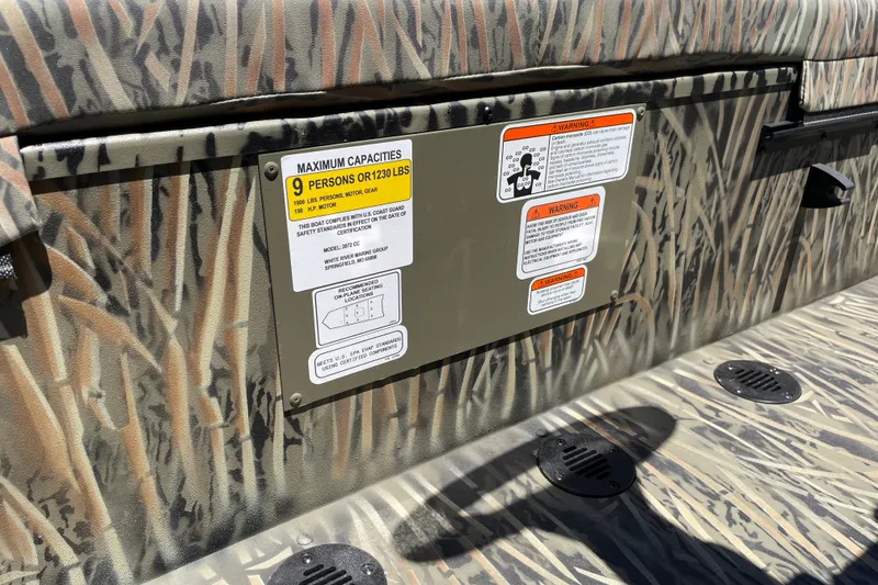 Slide: The Image of 2026 Tracker Grizzly 2072 CC boat with camouflage design and capacity warning labels. - 17