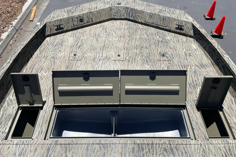 Slide: The Image of 2026 Tracker Grizzly 2072 CC boat with camo design and open storage compartments. - 7