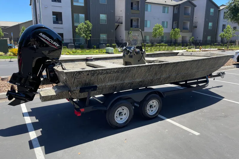Slide: The Image of 2026 Tracker Grizzly 2072 CC boat with Mercury engine on trailer in parking lot. - 2