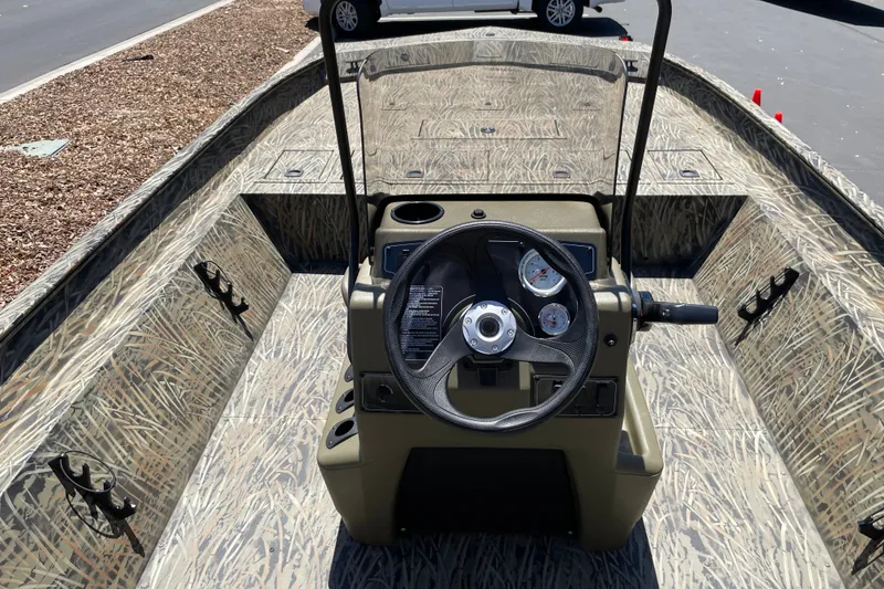 Slide: The Image of 2026 Tracker Grizzly 2072 CC boat interior with camouflage design and steering console. - 13