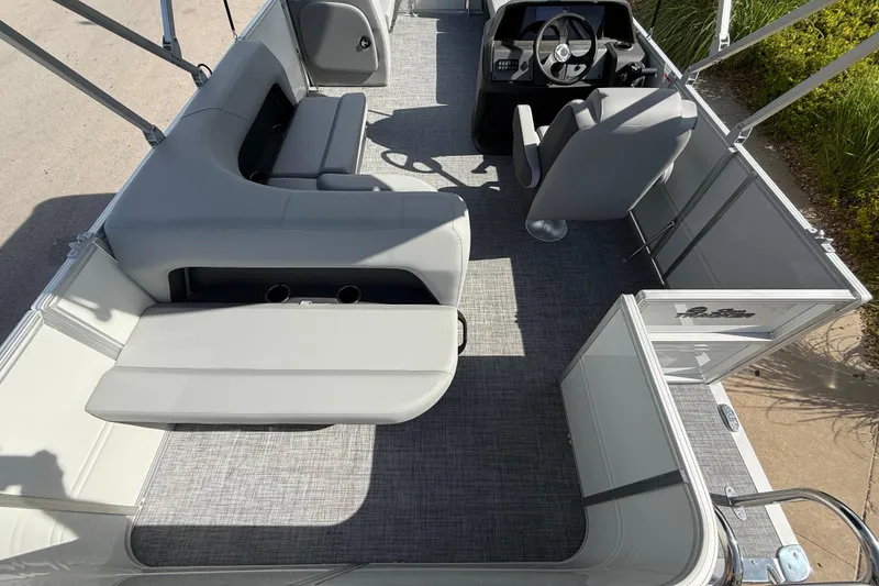 Slide: The Image of 2026 Sun Tracker Party Barge 18 DLX interior with gray seating and steering console. - 7