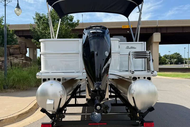 Slide: The Image of 2026 Sun Tracker Party Barge 18 DLX pontoon boat with outboard motor, parked outdoors. - 9