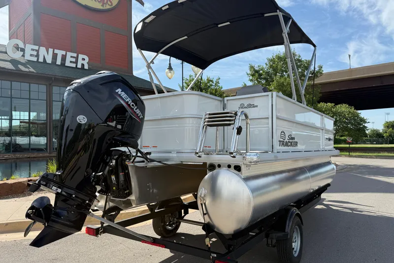 Slide: The Image of 2026 Sun Tracker Party Barge 18 DLX pontoon boat with Mercury engine, parked outdoors. - 10