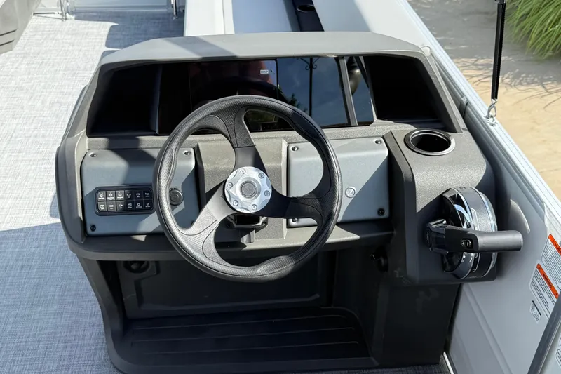 Slide: The Image of 2026 Sun Tracker Party Barge 18 DLX steering console with modern controls and cup holder. - 6