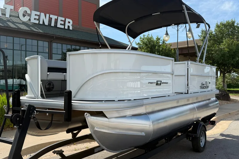 Slide: The Image of 2026 Sun Tracker Party Barge 18 DLX pontoon boat on trailer outside dealership. - 2