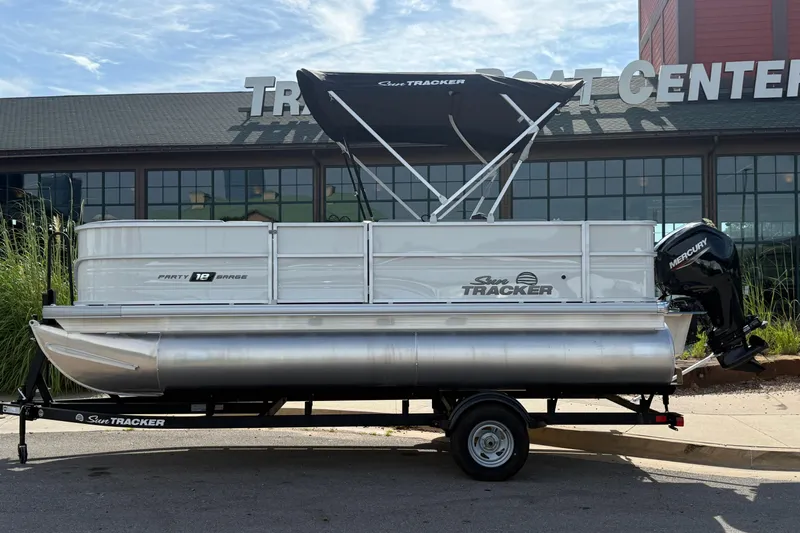 The Image of 2026 Sun Tracker Party Barge 18 DLX pontoon boat displayed outside a boat center. - 0