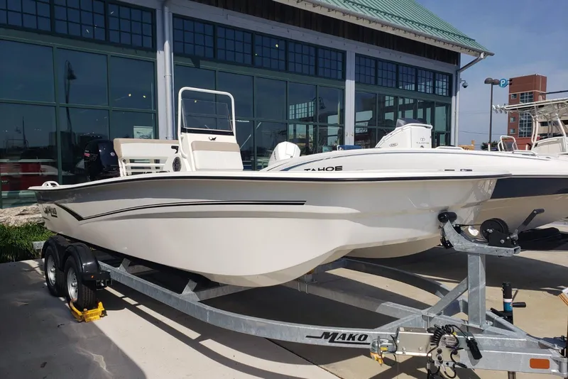 The Image of 2026 Mako Pro Skiff 19 CC boat on trailer, displayed outdoors near a building. - 0