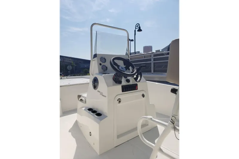 Slide: The Image of 2026 Mako Pro Skiff 19 CC boat console with steering wheel and controls. - 7