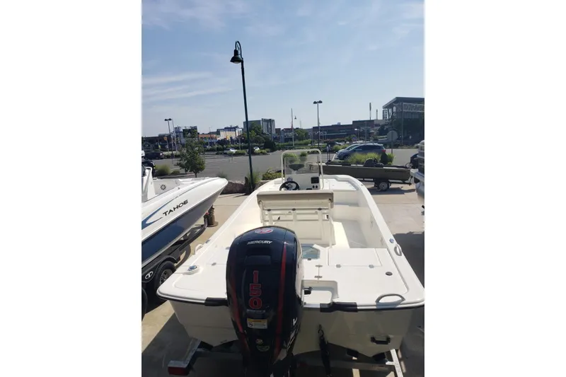 Slide: The Image of 2026 Mako Pro Skiff 19 CC boat with Mercury 150 engine in a parking lot. - 3