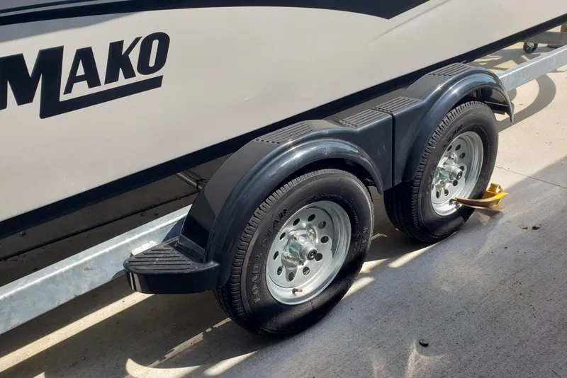 Slide: The Image of 2026 Mako Pro Skiff 19 CC boat trailer with dual wheels on concrete surface. - 11