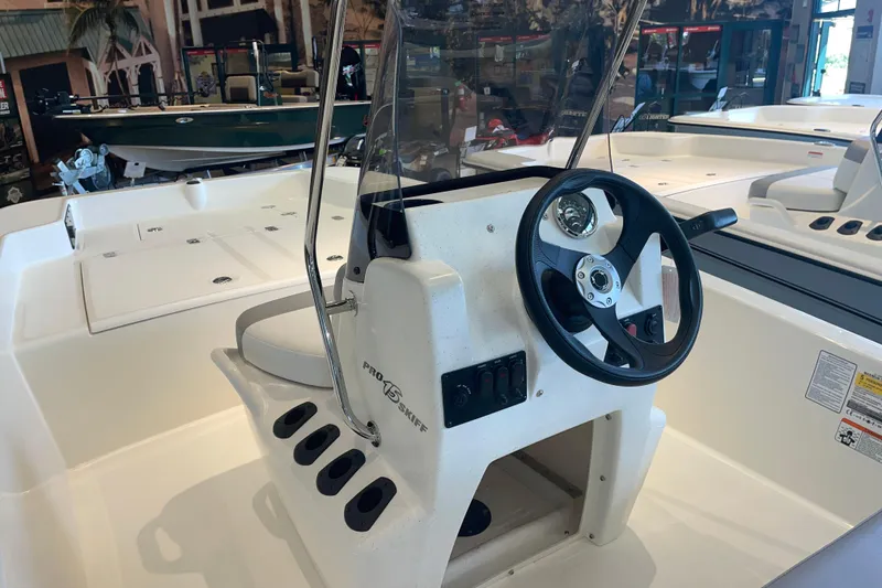 Slide: The Image of 2026 Mako Pro Skiff 15 CC boat interior with steering console and controls. - 3