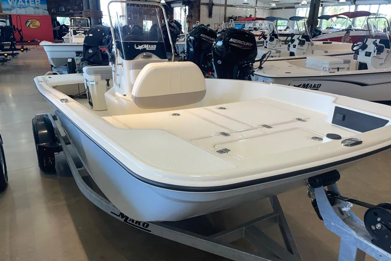 Slide: The Image of 2026 Mako Pro Skiff 15 CC boat displayed in showroom, featuring sleek design and modern features. - 2