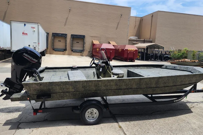 Slide: The Image of 2026 Tracker Grizzly 2072 CC boat with Mercury engine on trailer in industrial setting. - 2
