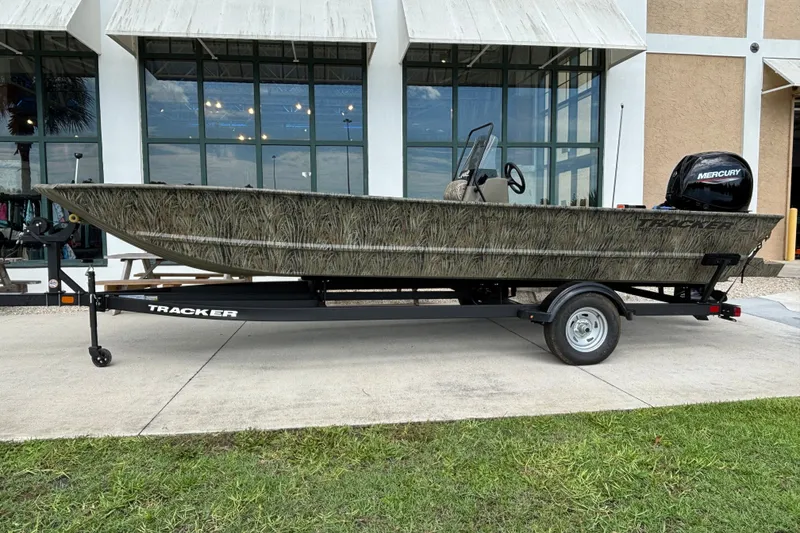 The Image of 2026 Tracker Grizzly 2072 CC boat on trailer, parked outside a building. - 0