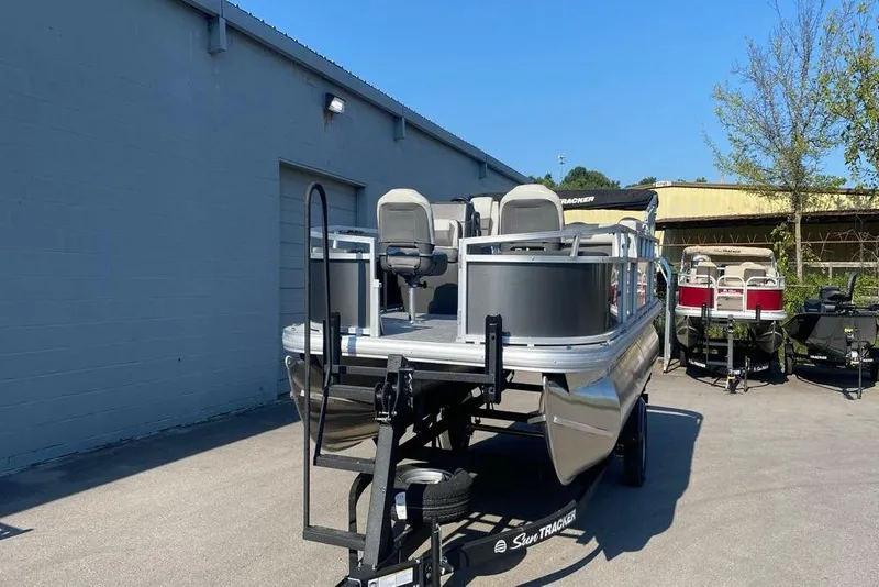 Slide: The Image of 2026 Sun Tracker Bass Buggy 18 DLX pontoon boat on trailer, outdoor display. - 2