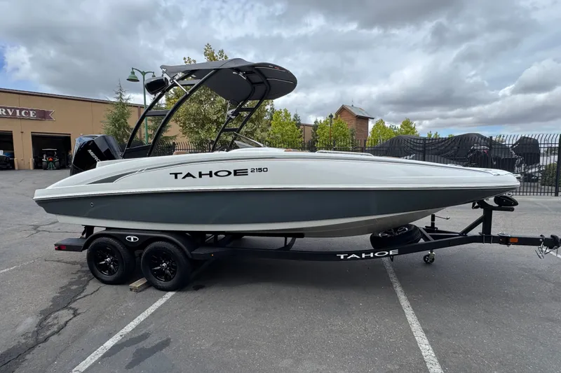 Slide: The Image of 2026 Tahoe 2150 boat on trailer, parked outdoors under cloudy sky. - 4