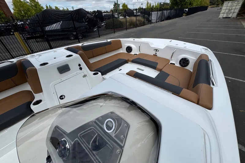 Slide: The Image of 2026 Tahoe 2150 boat interior with brown and black seating, parked in a lot. - 14