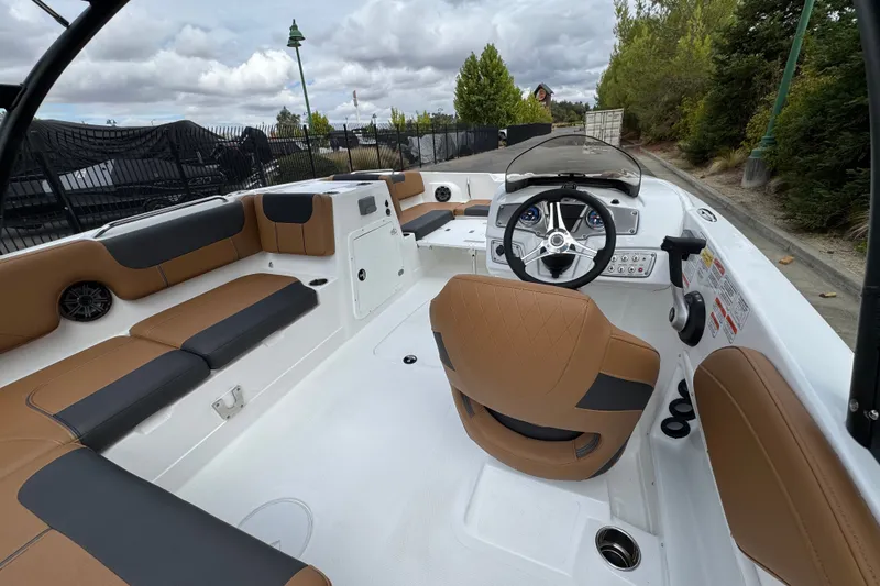 Slide: The Image of 2026 Tahoe 2150 boat interior with tan seating and modern steering console. - 11