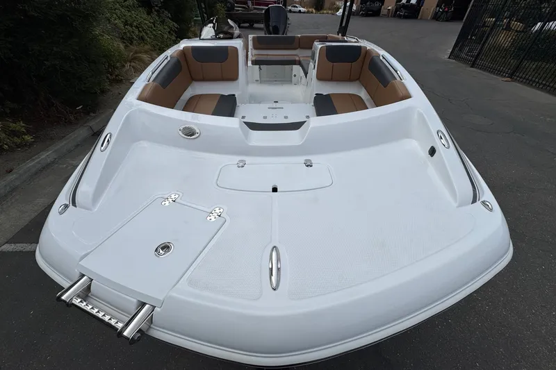 Slide: The Image of 2026 Tahoe 2150 boat with spacious seating and sleek design in a parking area. - 6