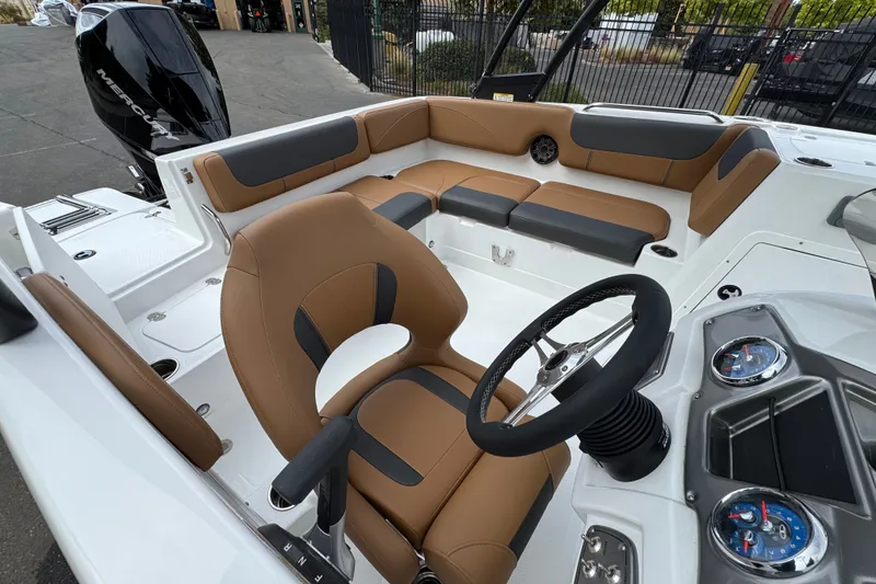 Slide: The Image of 2026 Tahoe 2150 boat interior with tan and gray seating, steering wheel, and dashboard. - 12