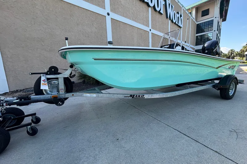 Slide: The Image of 2026 Mako Pro Skiff 17 CC boat on trailer, parked outside a building. - 48