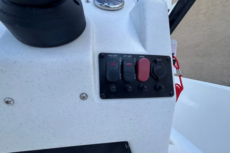 Slide: The Image of Control panel of 2026 Mako Pro Skiff 17 CC boat with switches and red safety cord. - 53