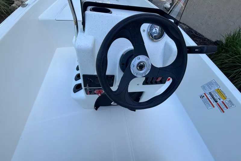 Slide: The Image of Steering console of 2026 Mako Pro Skiff 17 CC boat, featuring a black wheel. - 51