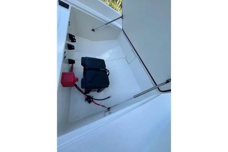 Slide: The Image of 2026 Mako Pro Skiff 17 CC interior storage compartment with battery and wiring. - 54