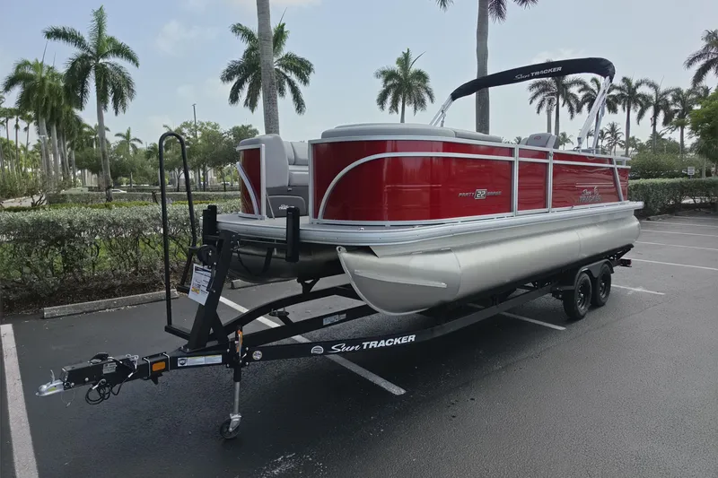 Slide: The Image of 2026 Sun Tracker Party Barge 22 RF DLX pontoon boat on trailer in parking lot. - 5