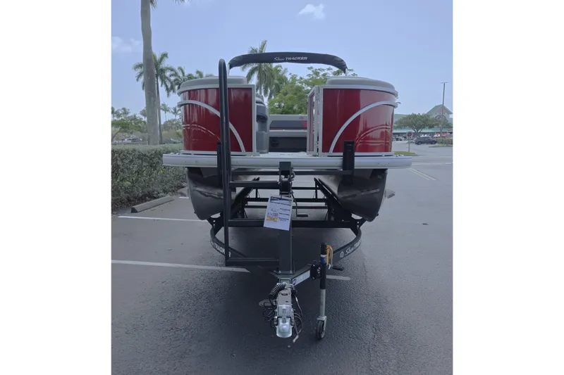 Slide: The Image of 2026 Sun Tracker Party Barge 22 RF DLX pontoon boat on trailer in parking lot. - 2
