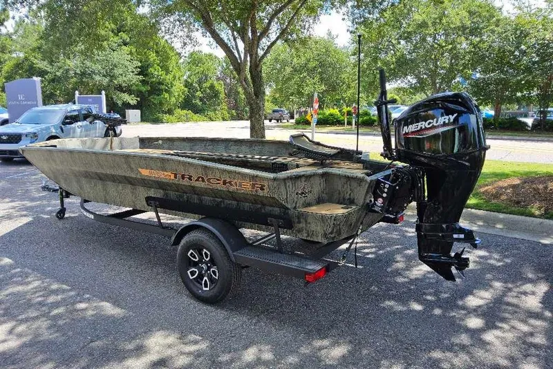 Slide: The Image of 2026 Tracker Grizzly 1756 T Marsh boat with Mercury engine on trailer in sunny parking lot. - 2
