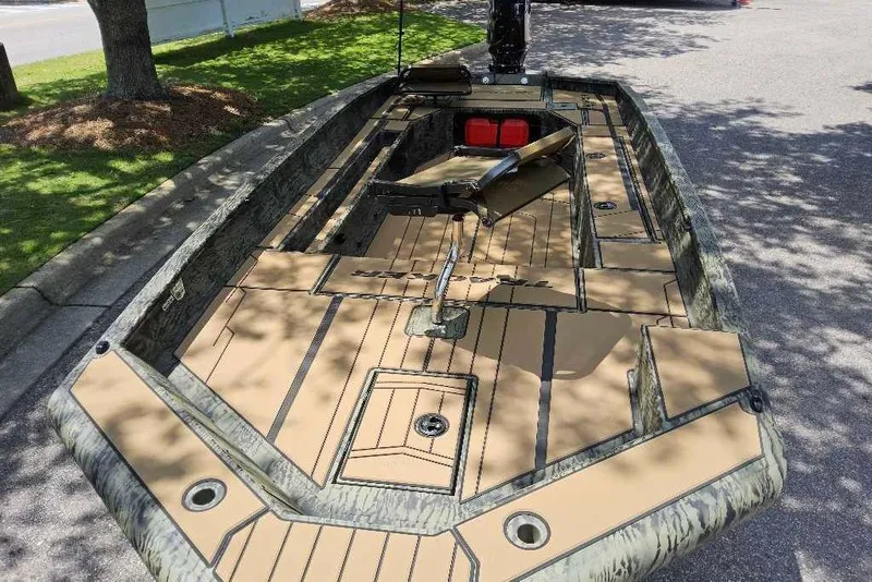 Slide: The Image of 2026 Tracker Grizzly 1756 T Marsh boat with camouflage design, parked outdoors. - 3