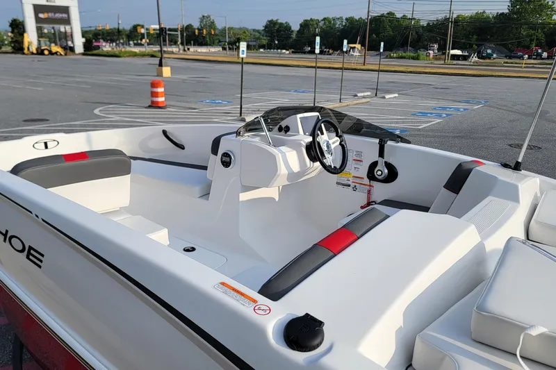 Slide: The Image of 2026 Tahoe T16 boat interior with modern steering and seating in a parking lot. - 3