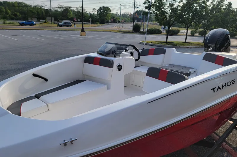 Slide: The Image of 2026 Tahoe T16 boat with red and gray seating, parked in a lot. - 4