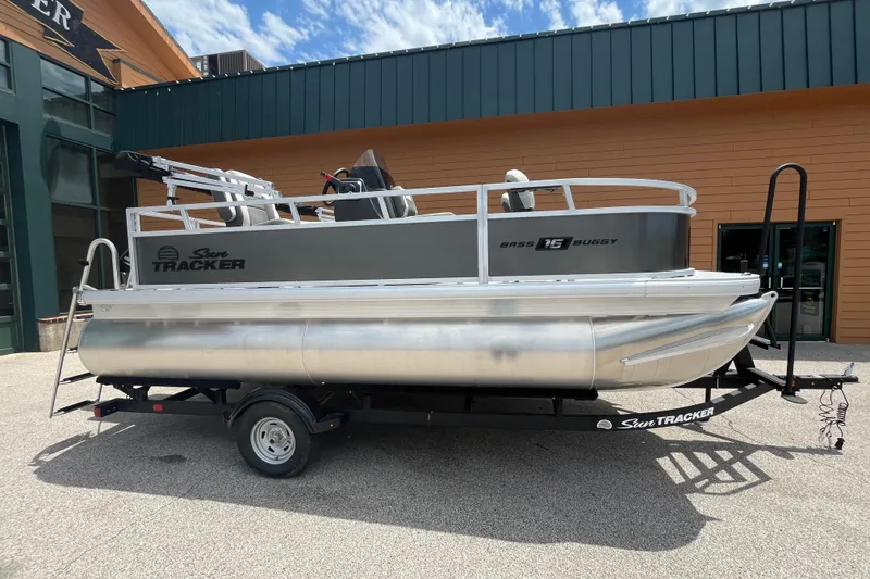 The Image of 2026 Sun Tracker Bass Buggy 16 XL Select pontoon boat on trailer, outdoor display. - 0