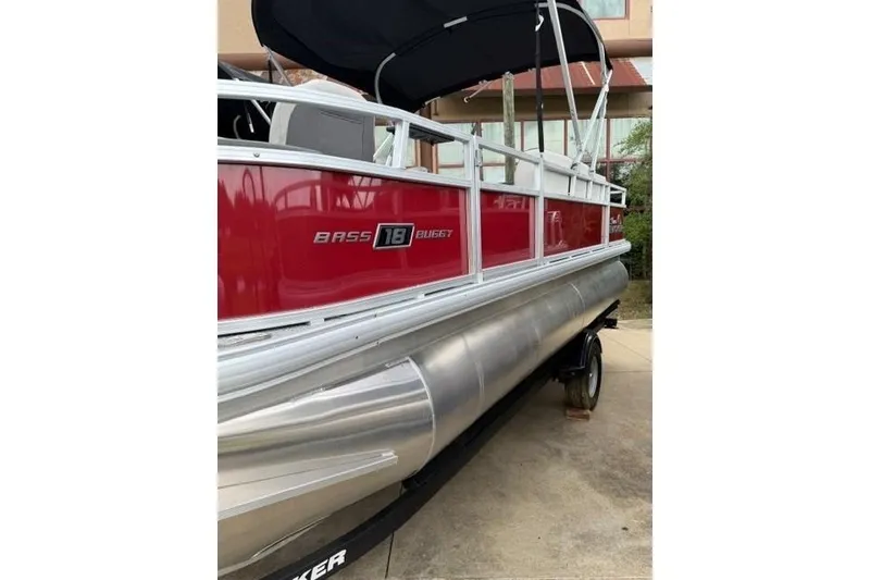 Slide: The Image of 2026 Sun Tracker Bass Buggy 18 DLX pontoon boat with red exterior and black canopy. - 85
