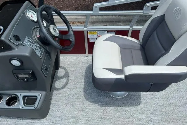 Slide: The Image of 2026 Sun Tracker Bass Buggy 18 DLX boat interior with steering console and cushioned seat. - 5