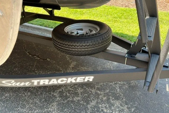 Slide: The Image of Trailer of 2026 Sun Tracker Bass Buggy 18 DLX with spare tire on asphalt. - 104