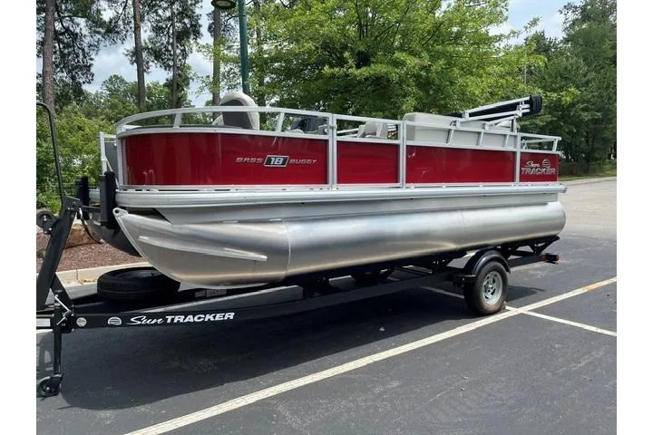 The Image of 2026 Sun Tracker Bass Buggy 18 DLX pontoon boat on trailer in parking lot. - 0
