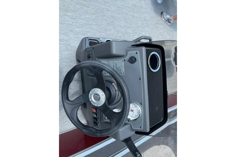 Slide: The Image of 2026 Sun Tracker Bass Buggy 18 DLX steering console with cup holder and gauge. - 12