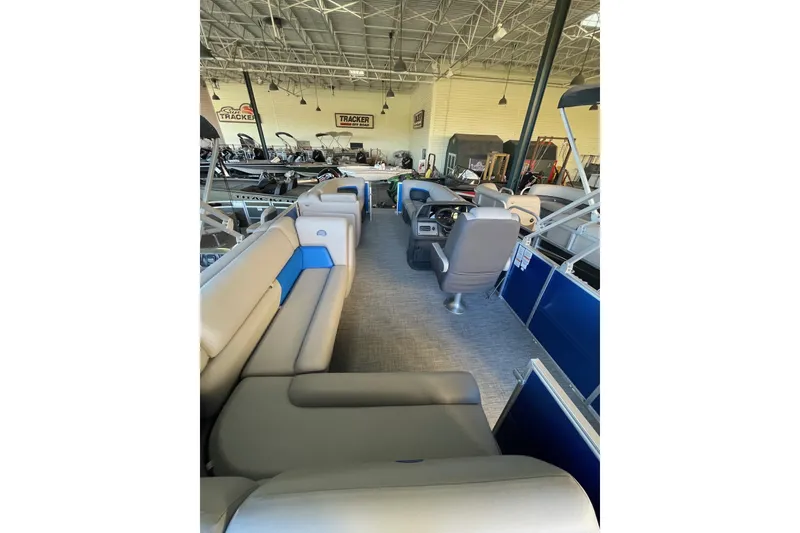 Slide: The Image of 2026 Sun Tracker Party Barge 20 DLX interior with spacious seating in showroom. - 5