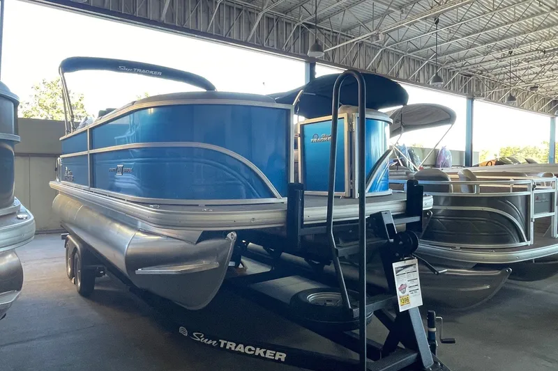 The Image of 2026 Sun Tracker Party Barge 20 DLX pontoon boat displayed in a showroom. - 0