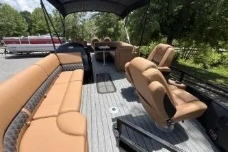 Slide: The Image of 2026 Ranger 223FC boat interior with tan seating and canopy, parked outdoors. - 8